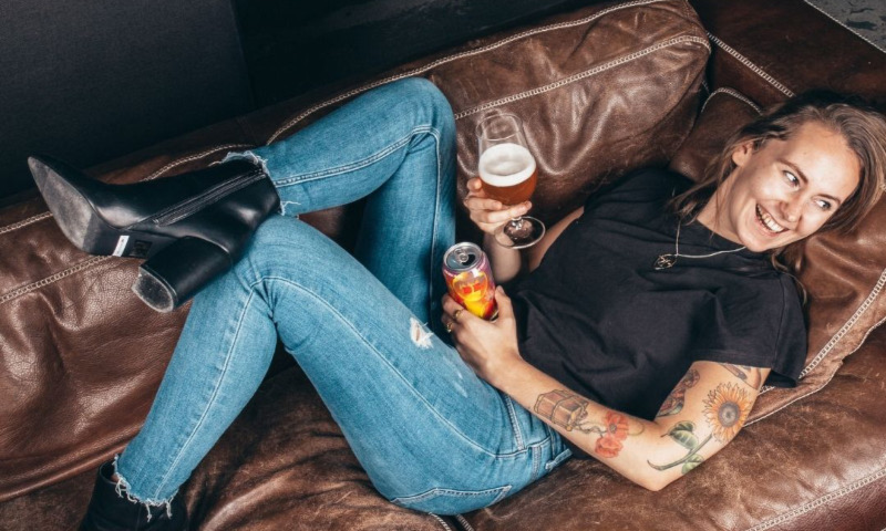 Vrouw met bier op de bank